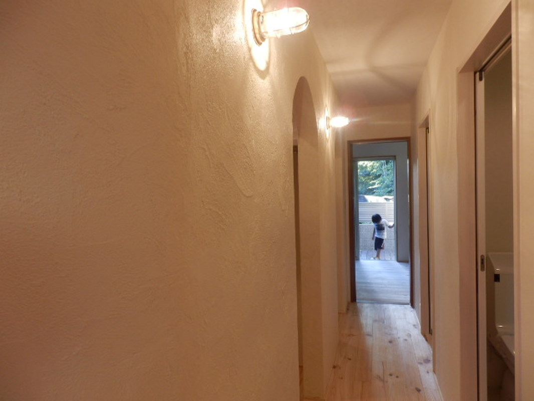 １階廊下は漆喰壁にアーチ型のウオークインクローゼット、照明はおしゃれなマリンランプ